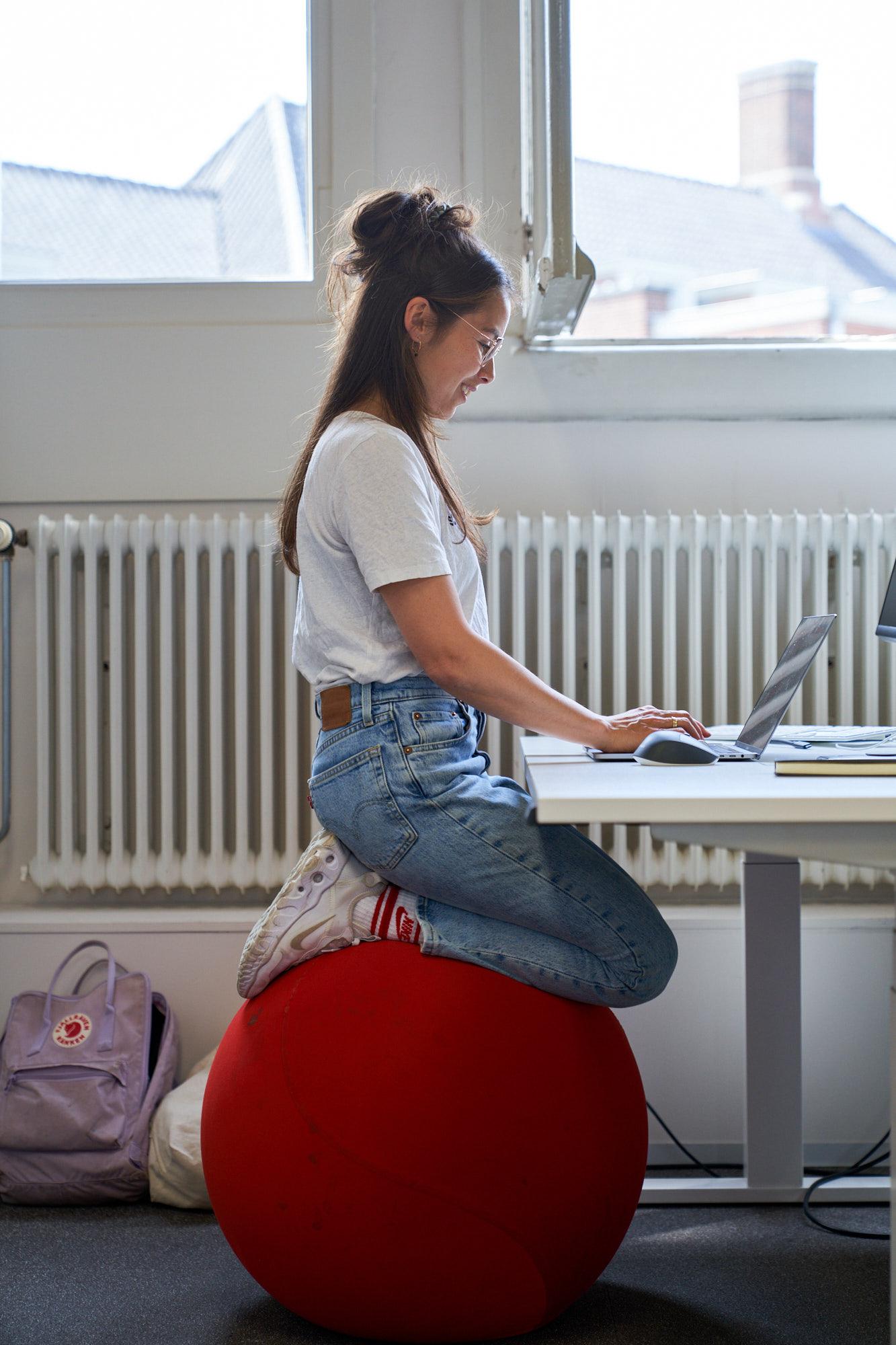 Woman sitting on an ergnomic ball