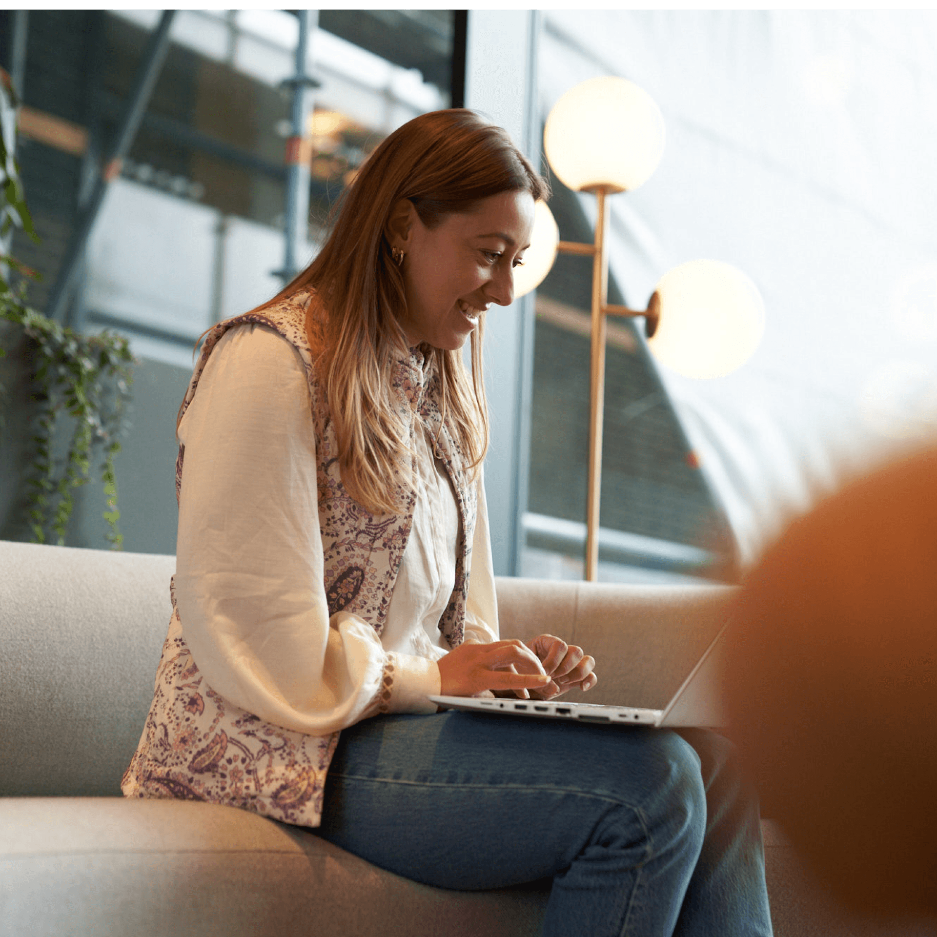 Woman working on laptop while smiling