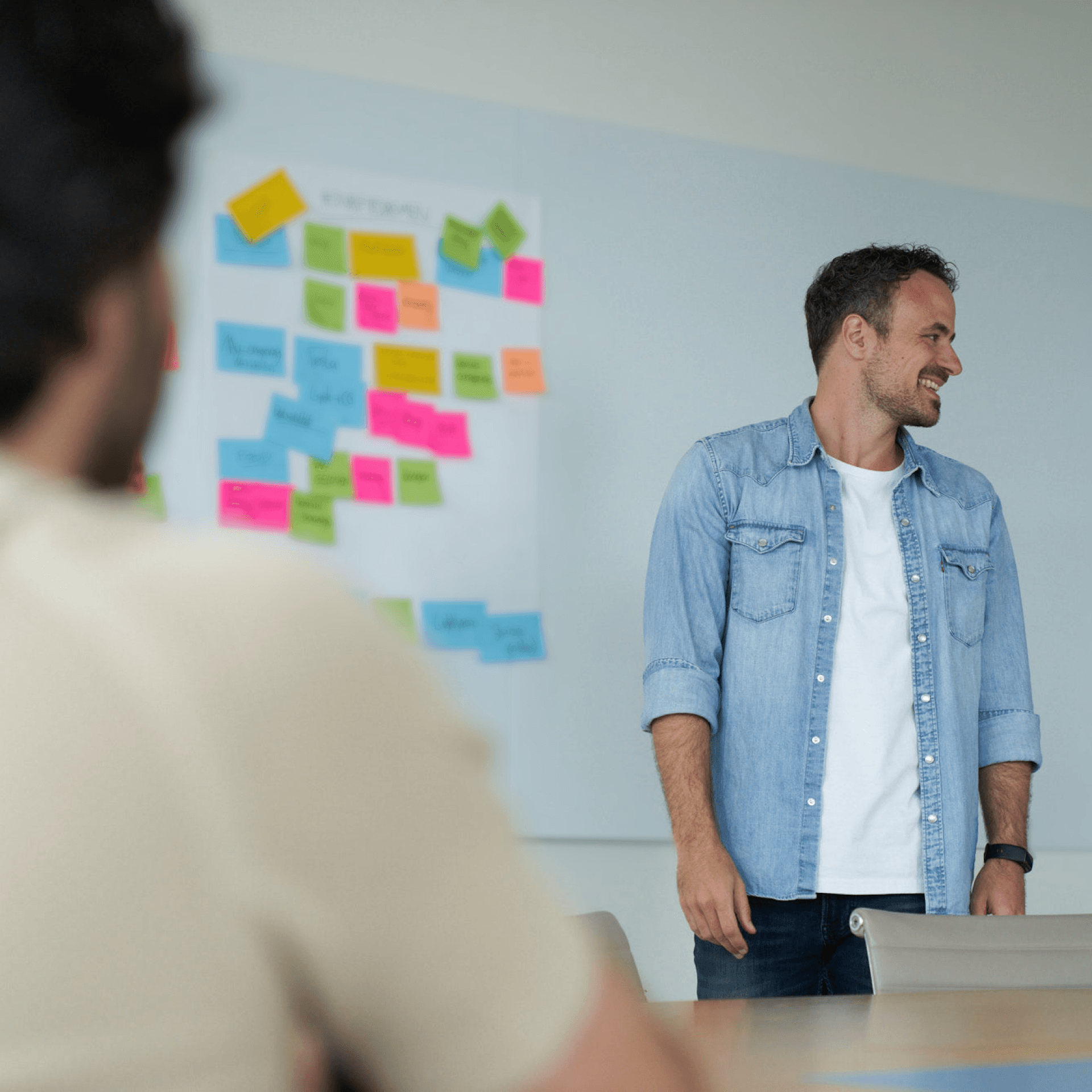 Person standing in front of whiteboard with post-it's