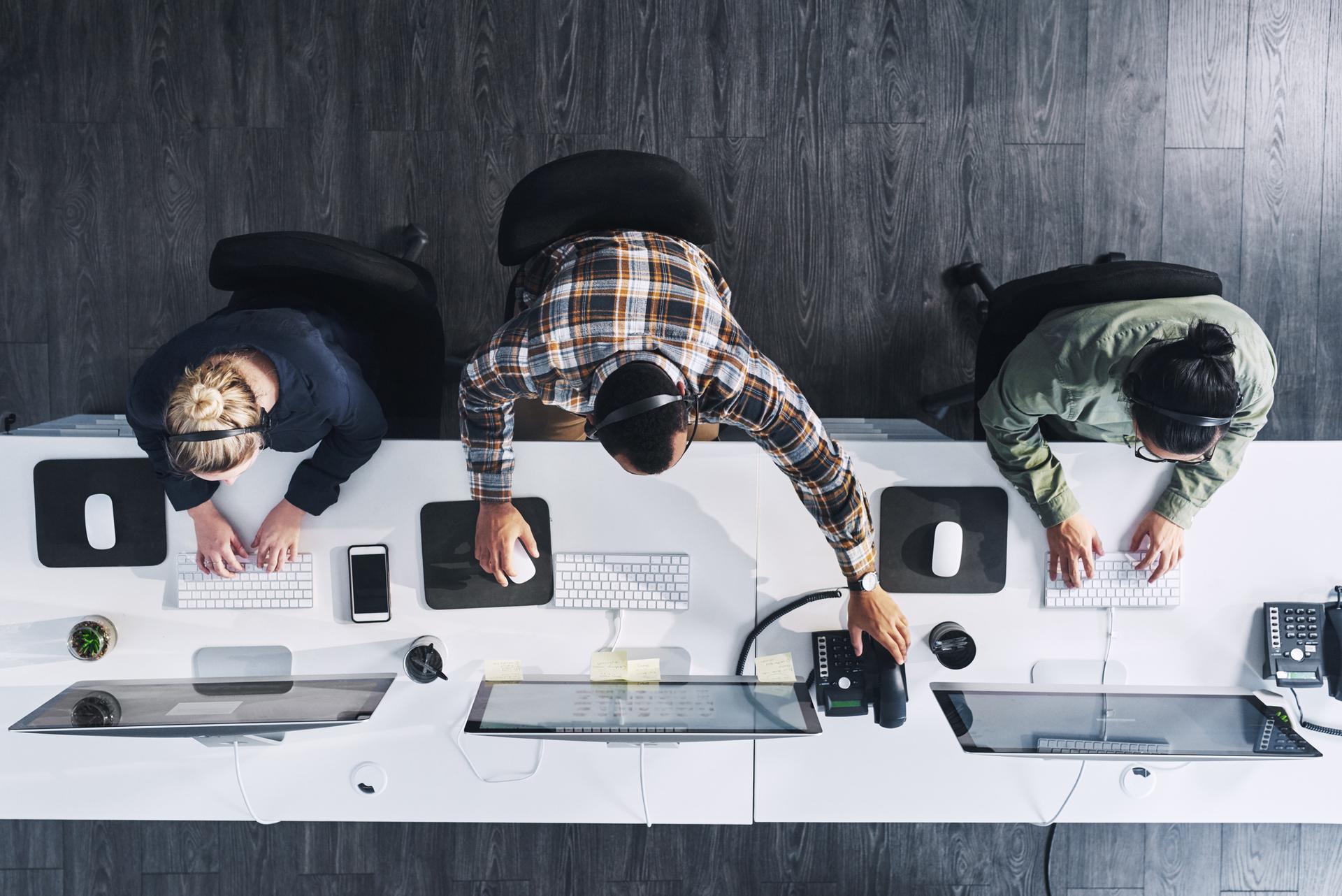 3 people working at desk from above