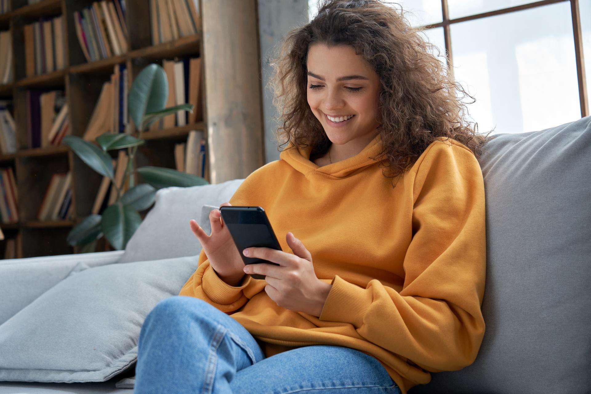 Person sitting on couch with phone