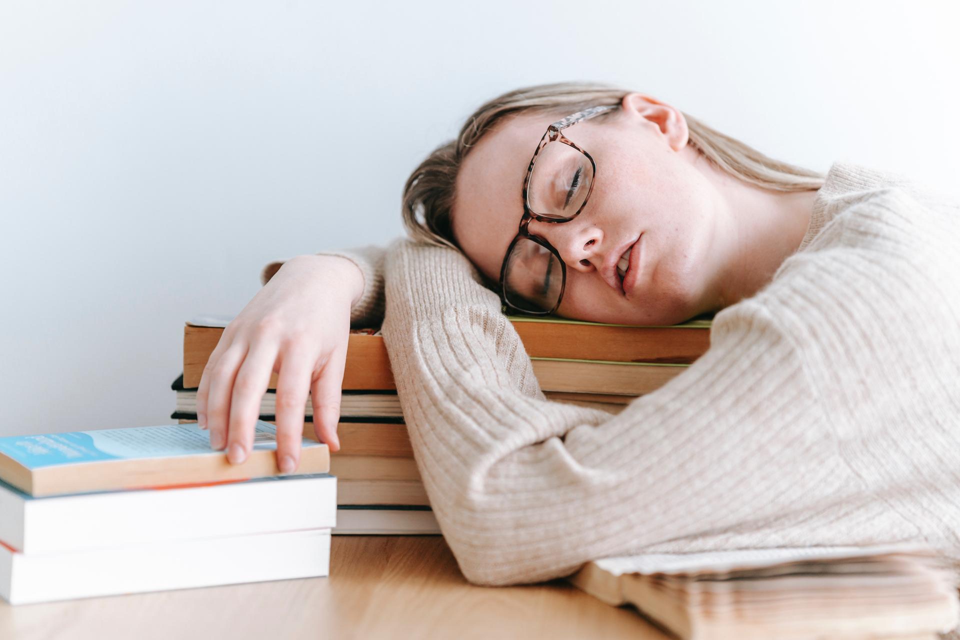 woman sleeping on books