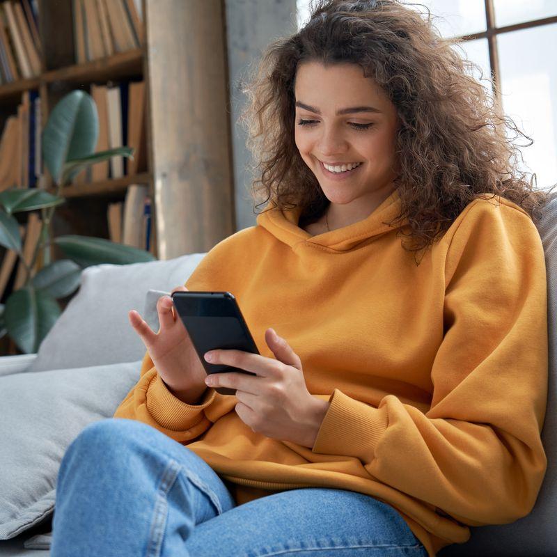 Person sitting on couch with phone