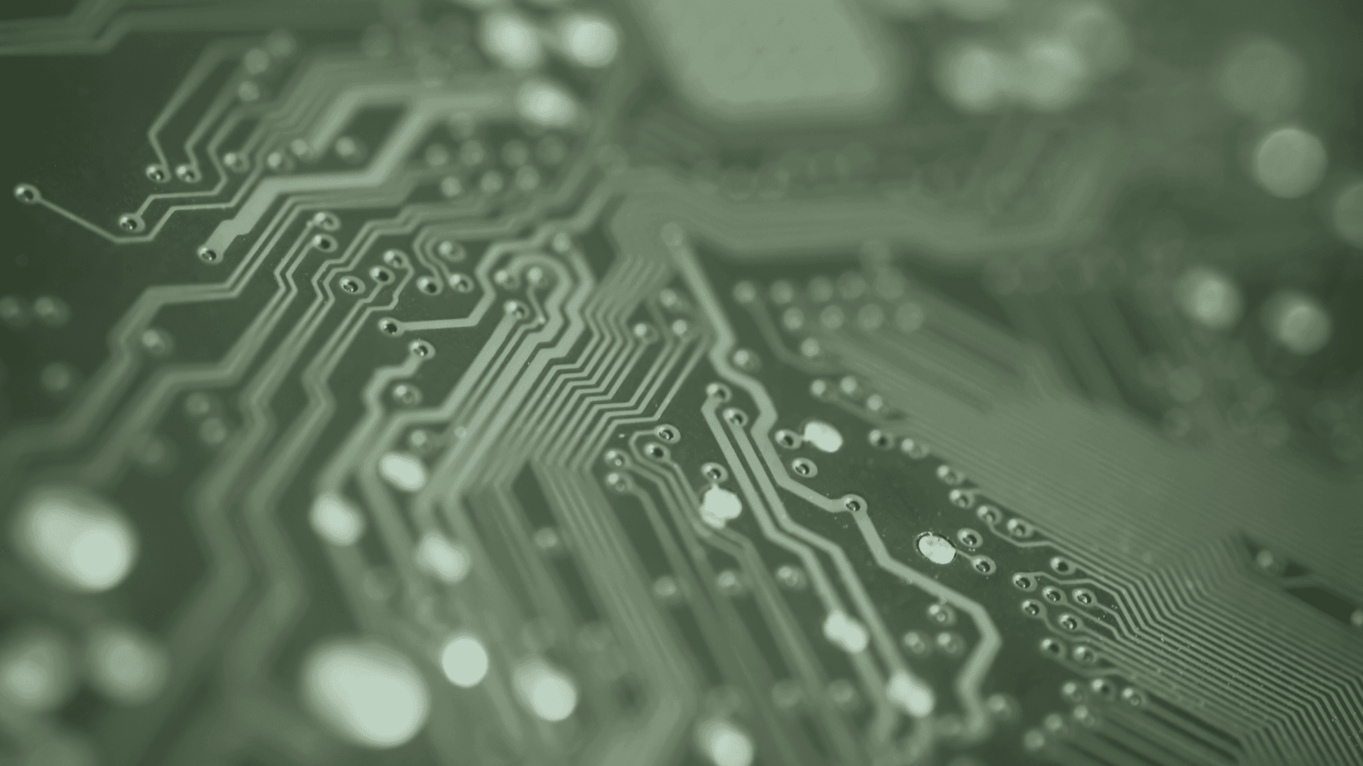 Close-up of a green printed circuit board showing intricate pathways and solder joints.