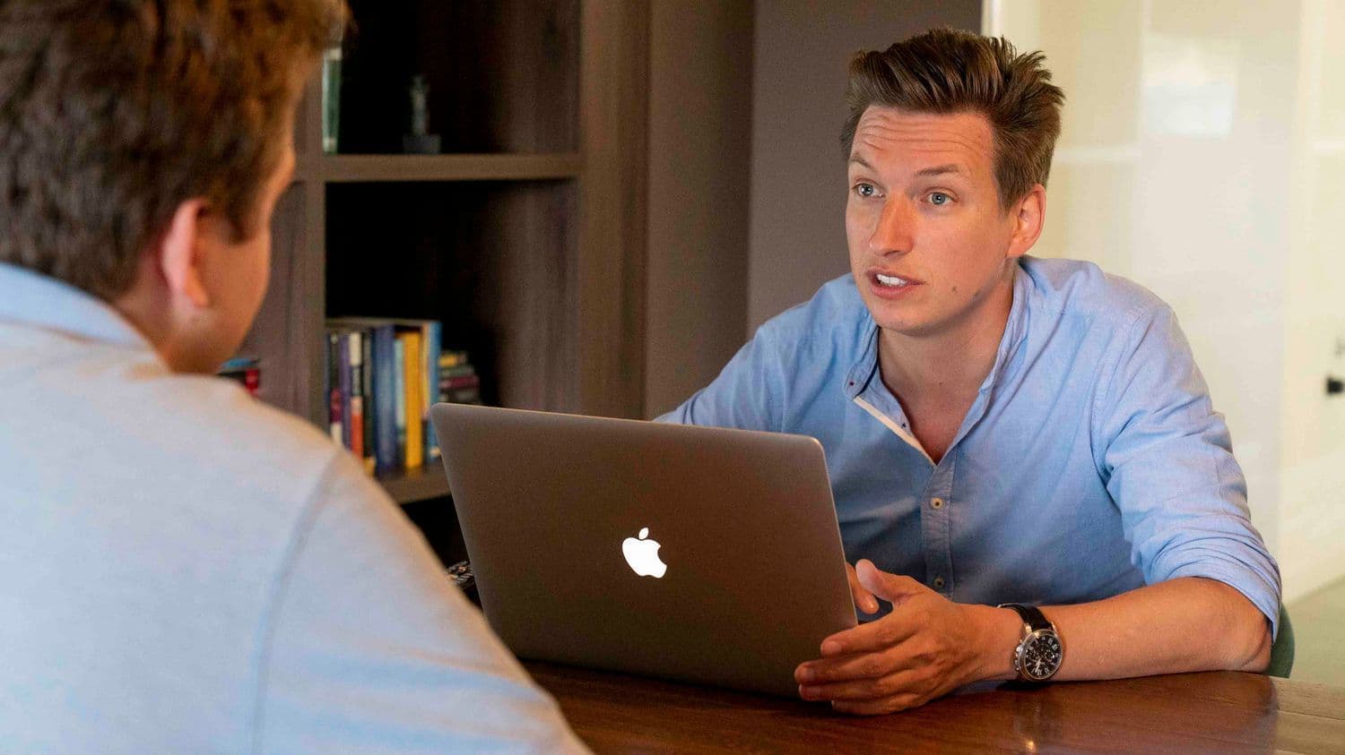 Tech in conversation while working on Mac